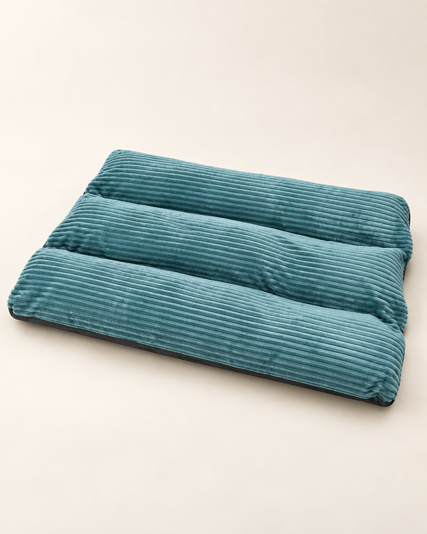 Teal-green rectangular PurrClean pet mattress with three parallel corduroy channels on an ivory background.