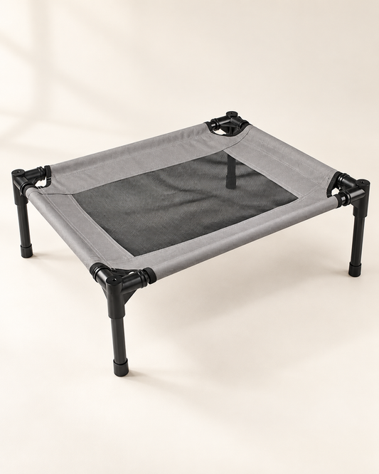 Compact gray elevated pet cot with black mesh sleeping panel, black frame and four legs on ivory.