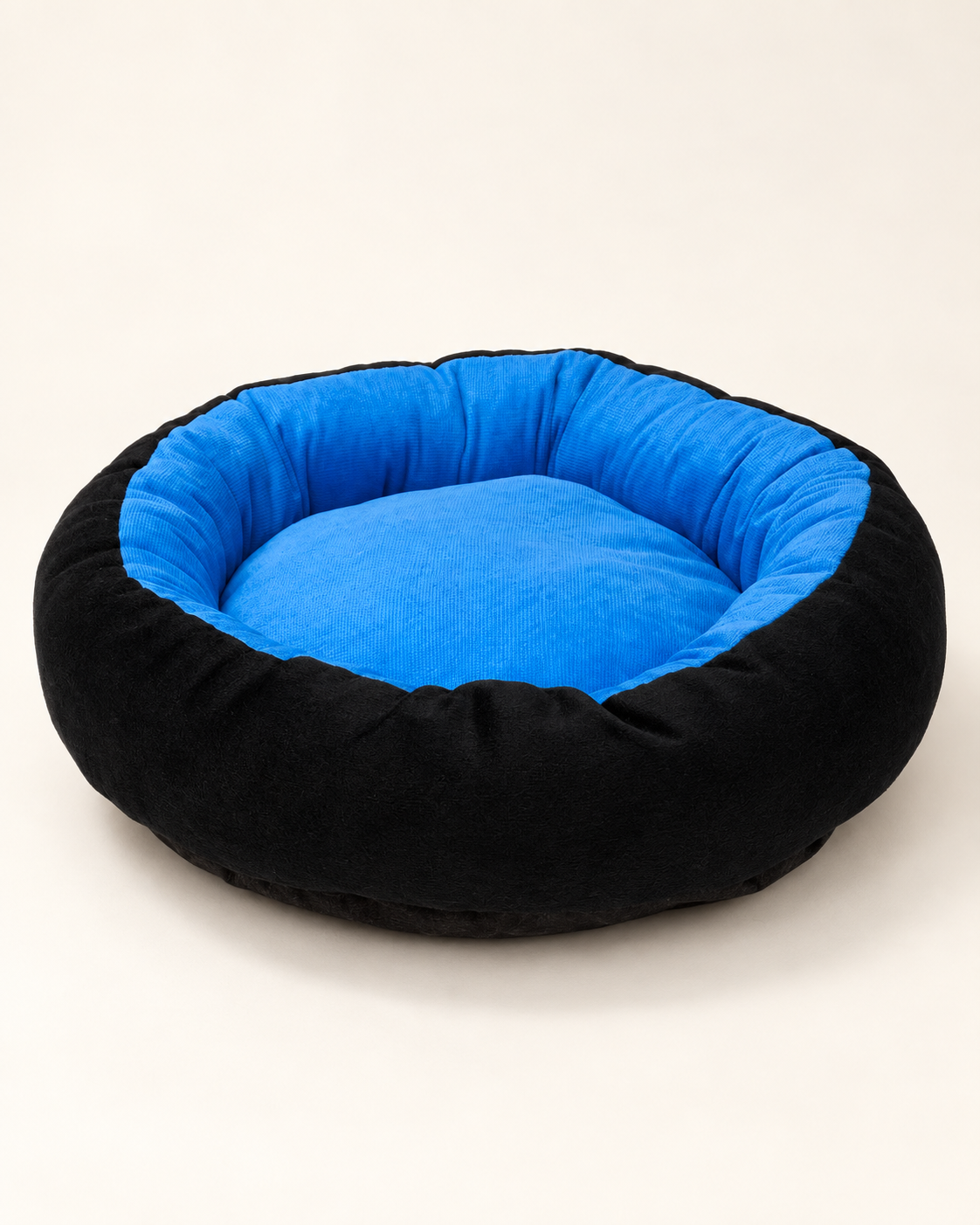 Blue cushioned pet bed with a softly rounded eight-sided shape, padded blue lining and black outer wall.