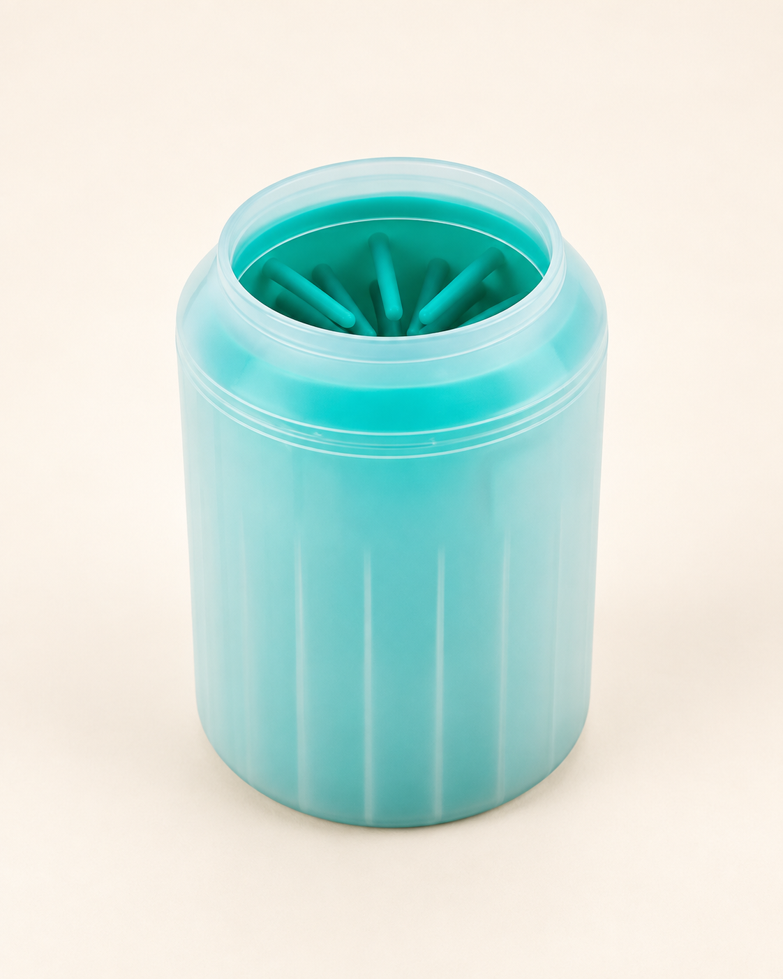Green manual paw cleaner cup with translucent shell and turquoise inner bristles on an ivory background.