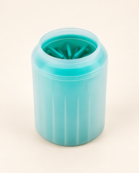 Green manual paw cleaner cup with translucent shell and turquoise inner bristles on an ivory background.